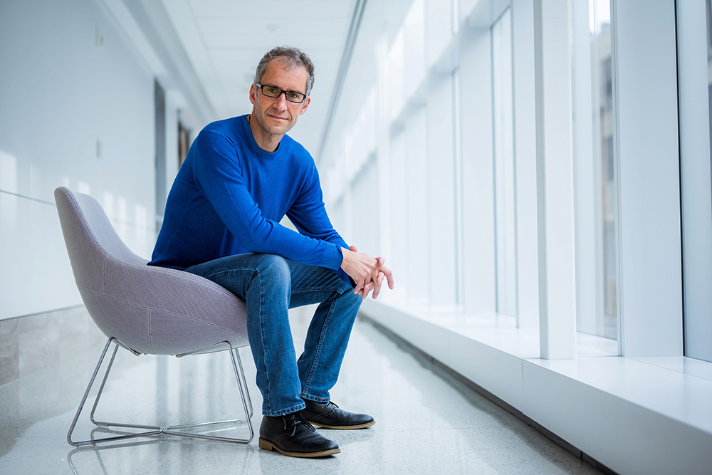 Prof Jacopo Buongiorno seated in a hallway with windows, MIT